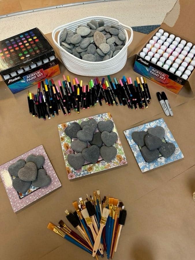 painting supplies and heart-shaped rocks